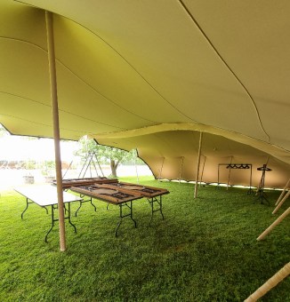 Tan stretch tent being used for a VIP holding area in London before a concert